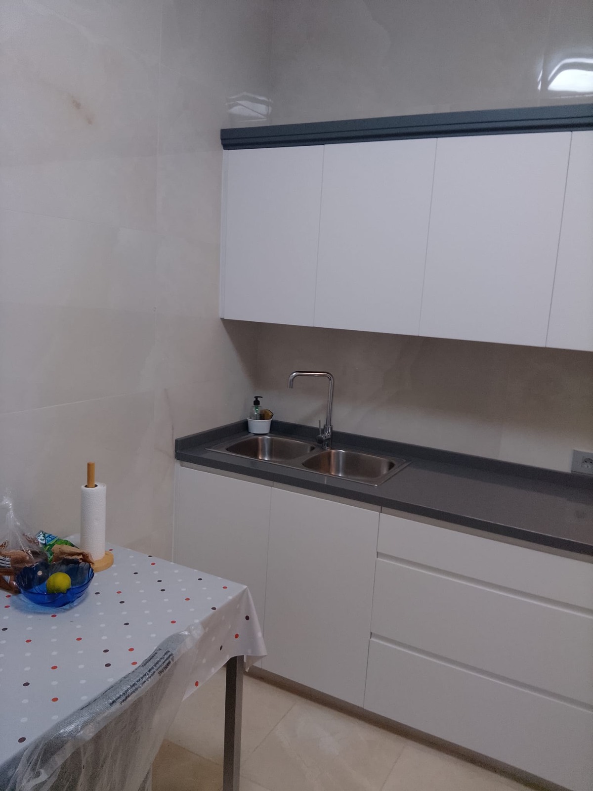 Cocina reformada por Pedro Heredia con muebles blancos y encimera gris