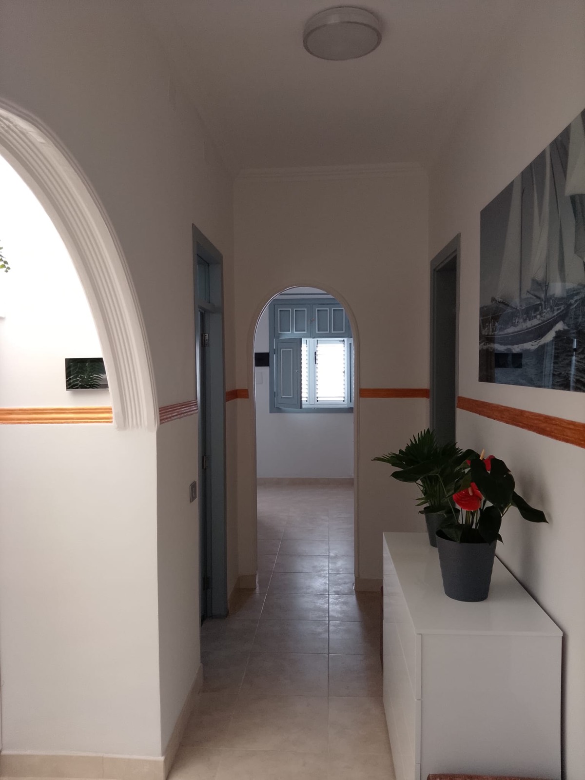 Pasillo con arcos de escayola y suelo porcelánico reformado